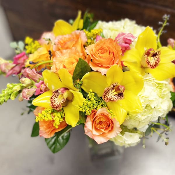 Bouquet of yellow orchids, peach roses, and white hydrangeas