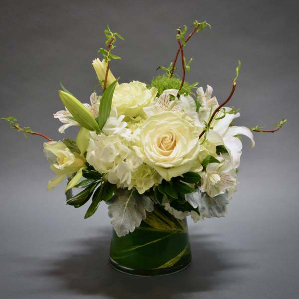 White floral arrangement in a green glass vase