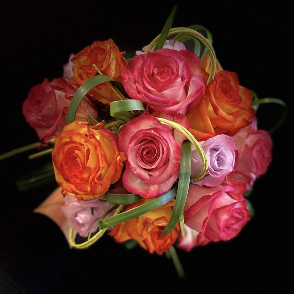 Bouquet of pink and orange roses with decorative grass loops