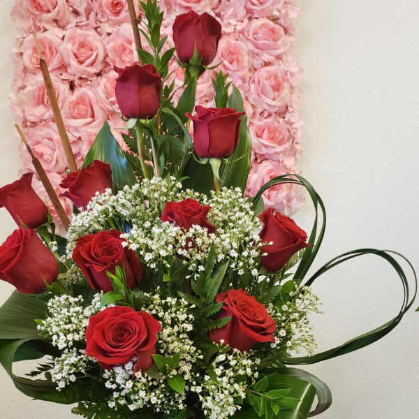 Basket arrangement of red roses with white filler flowers