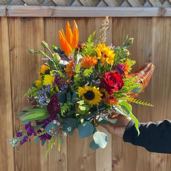 Handheld bouquet with sunflowers, roses, and orange blooms