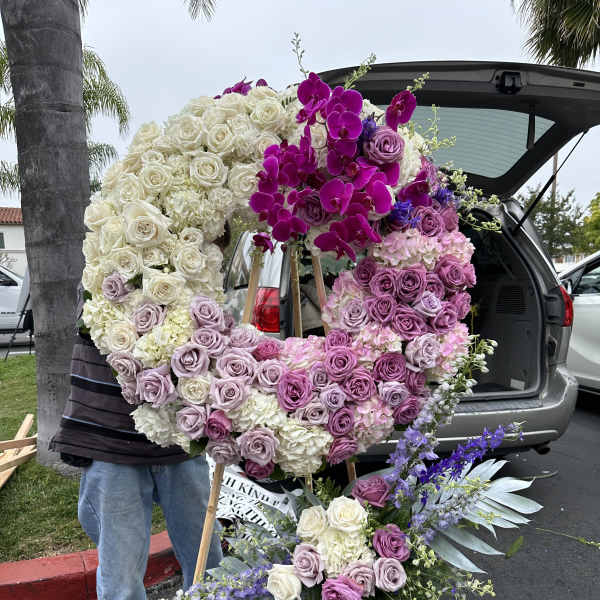 Large floral wreath with pink, purple, and white roses on an easel