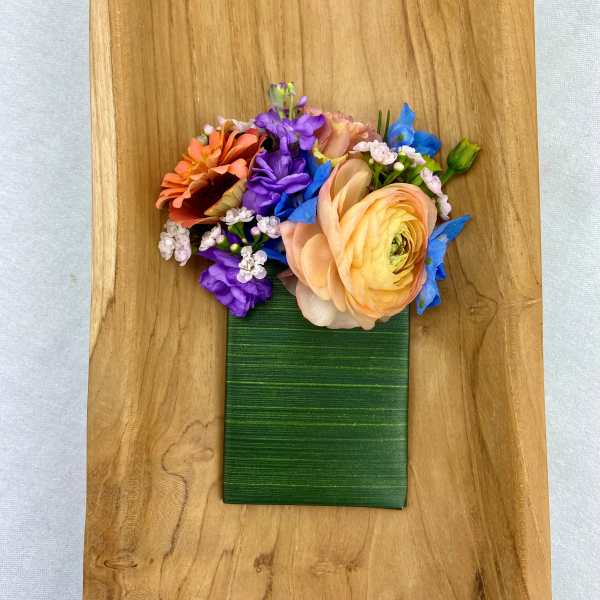 Colorful flower arrangement on a green rectangular base