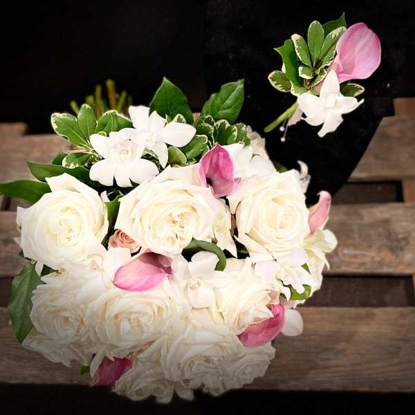 Bouquet of white roses and pink orchids with green foliage