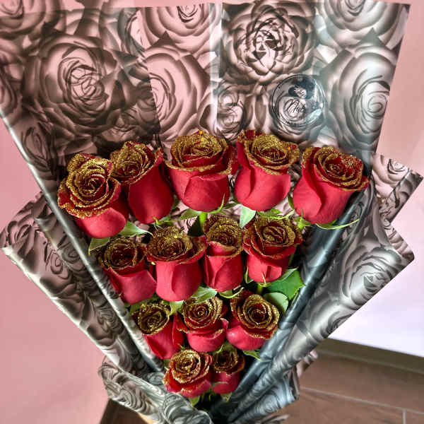 Bouquet of red roses wrapped in black-and-silver floral paper
