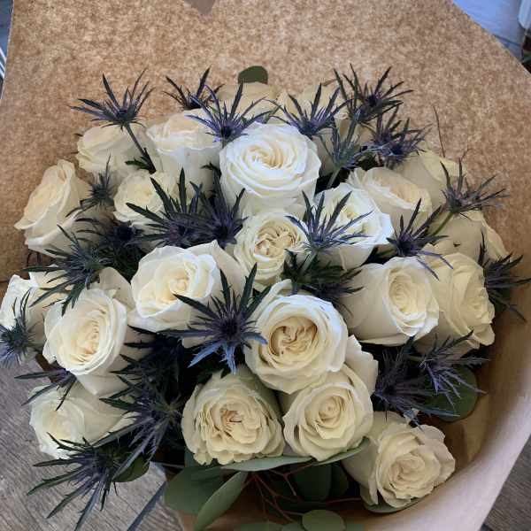 Bouquet of white roses with dark blue thistle-like accents