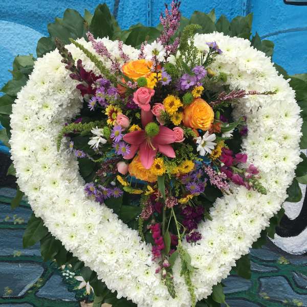 Heart-shaped floral wreath with white chrysanthemums and a colorful center bouquet