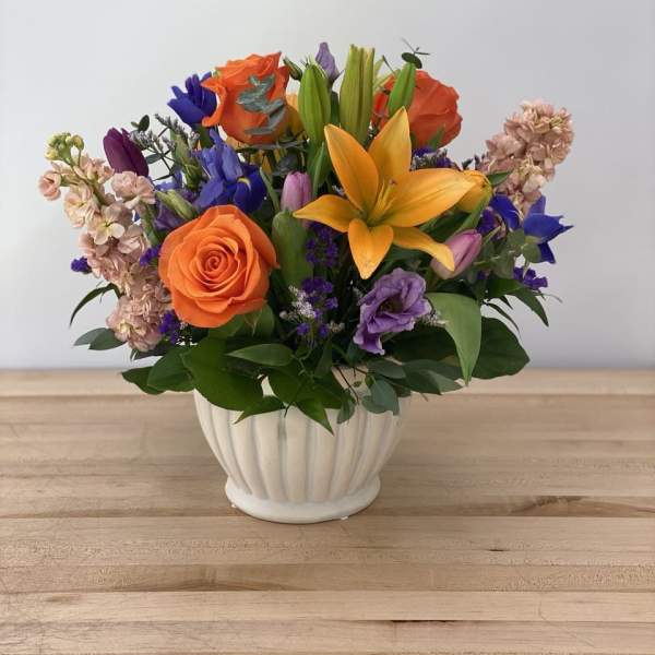 Colorful bouquet of roses and lilies in a white vase