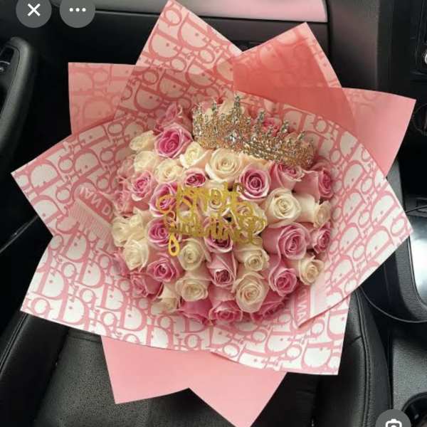 Pink and cream rose bouquet wrapped in patterned pink paper