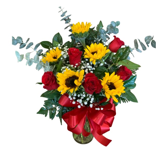 Bouquet of red roses and yellow sunflowers in a glass vase with a red ribbon