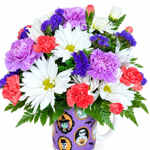 Bouquet of daisies, carnations, and purple filler flowers in a Halloween mug