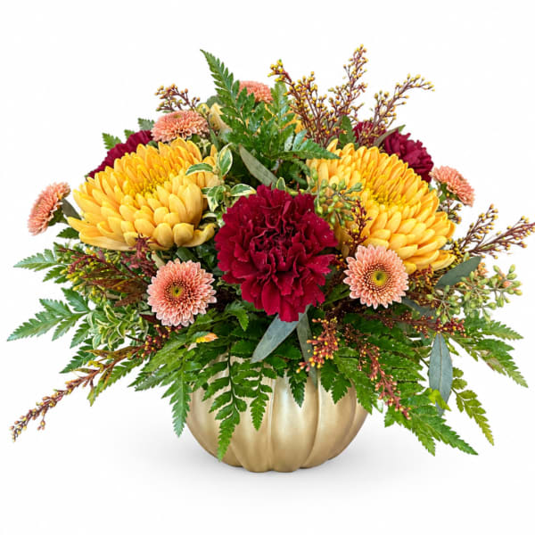 Yellow and burgundy flowers arranged in a gold pumpkin vase