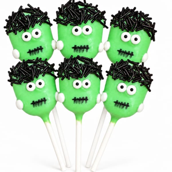 Six green Frankenstein face cake pops with white sticks on a white background.