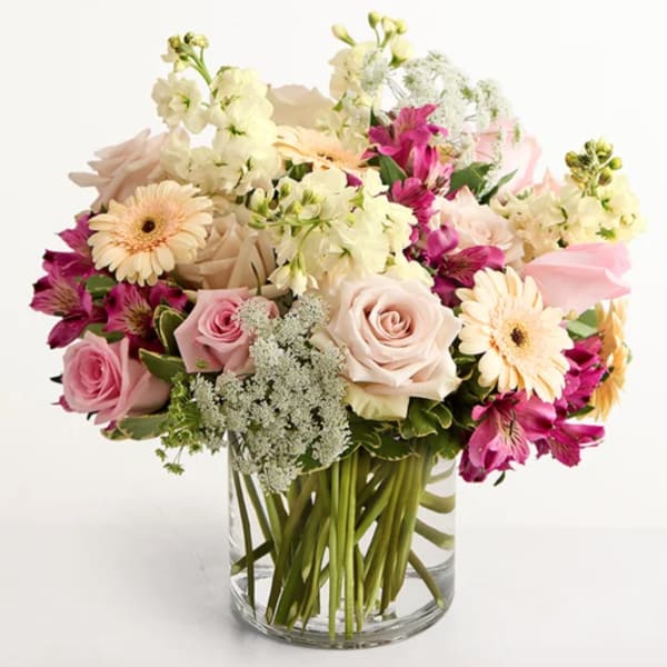 Pink and cream mixed bouquet in a clear glass vase
