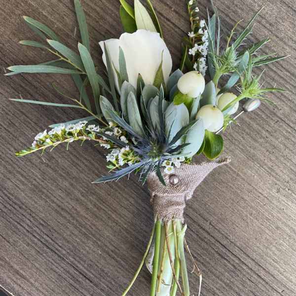 Boutonniere with a white rose and blue-green foliage