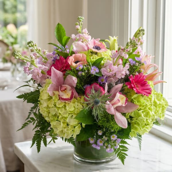 Mixed pink and green floral arrangement in a glass vase