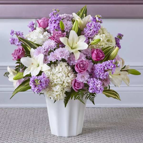 Pink and white bouquet with lilies and roses in a white vase