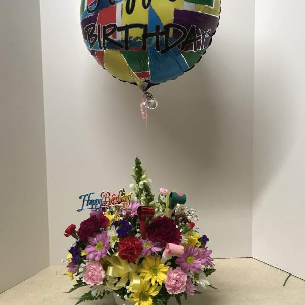 Birthday flower arrangement with a colorful balloon above mixed blooms