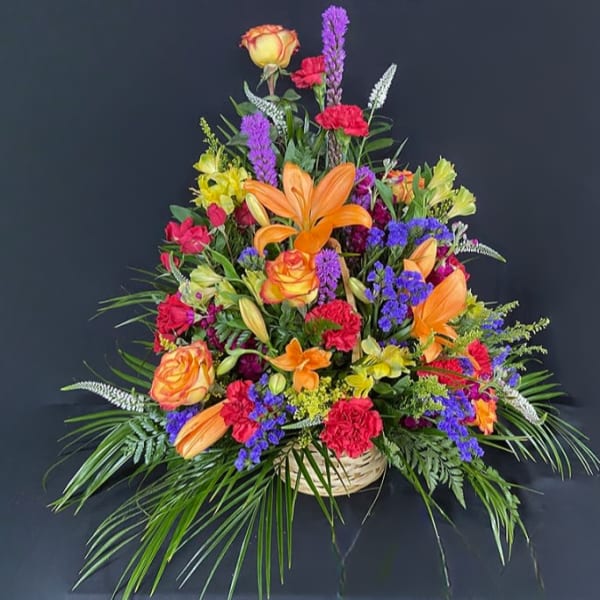 Colorful mixed flower arrangement in a woven basket
