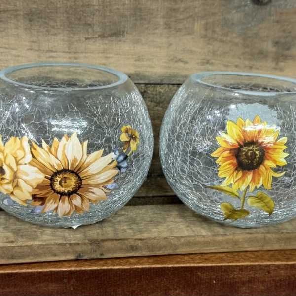 Four crackled glass bowls with painted floral designs on a wooden shelf