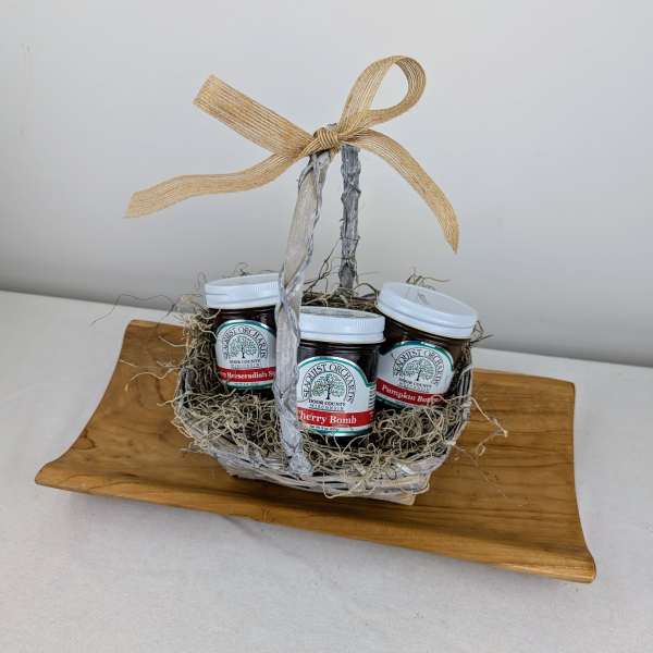 Gift basket with three jam jars on a wooden tray