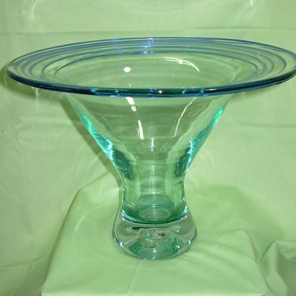 Blue glass pedestal bowl on a green cloth