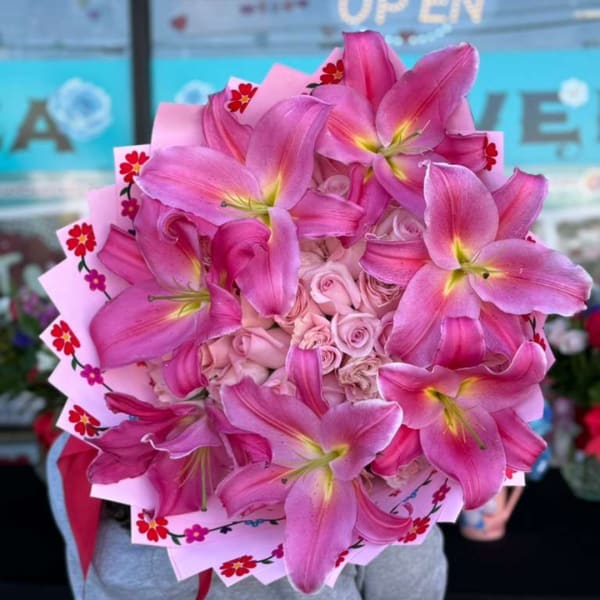 Pink lily and rose bouquet wrapped in patterned paper