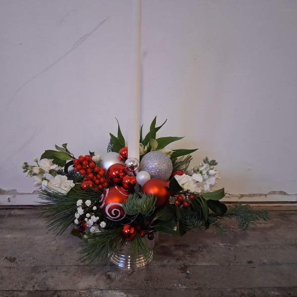 Holiday floral arrangement with red and silver ornaments in a metal container