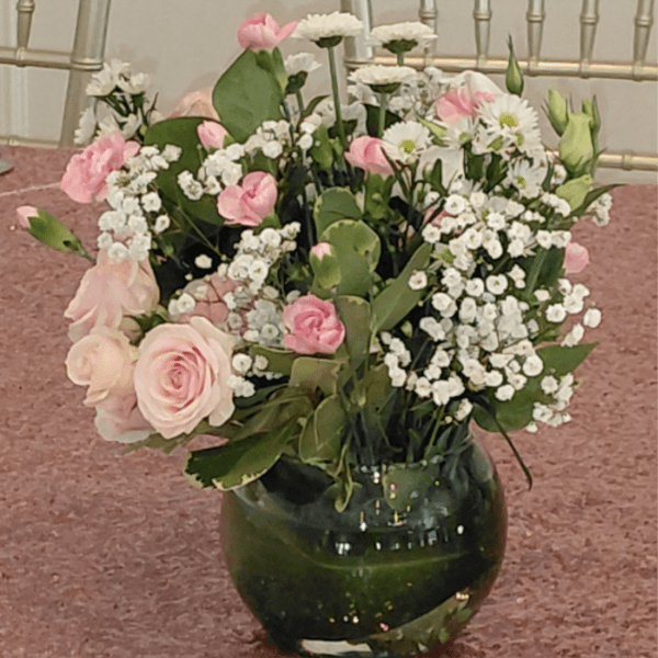 Pink and white flowers arranged in a dark glass vase