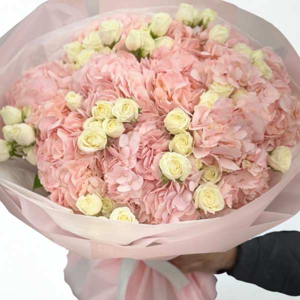 Pink hydrangea and cream rose bouquet wrapped in pale pink paper
