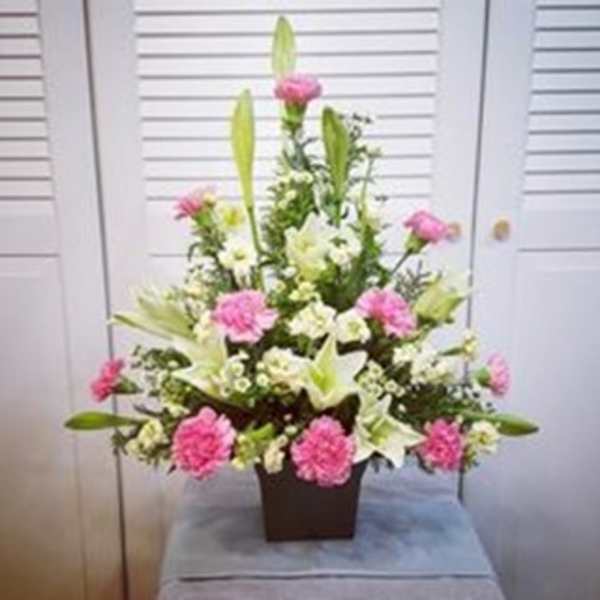 Pink and white floral arrangement in a square vase