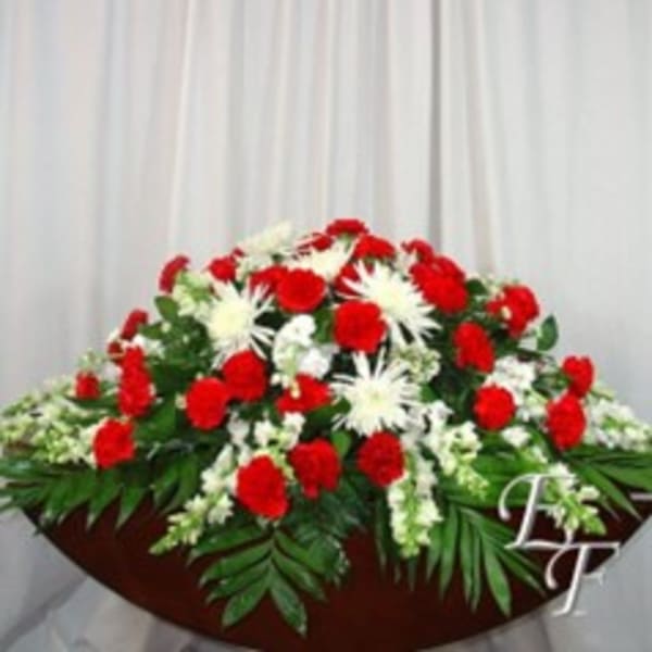 Red and white floral casket spray with palm leaves
