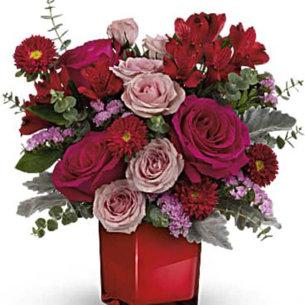 Pink and red rose bouquet in a red square vase