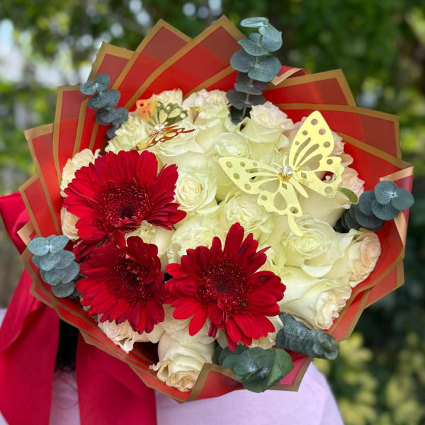 Bouquet of white roses and red gerbera daisies with butterfly accents