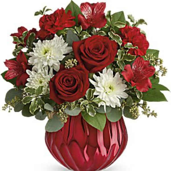 Red roses and white daisies in a red glass vase