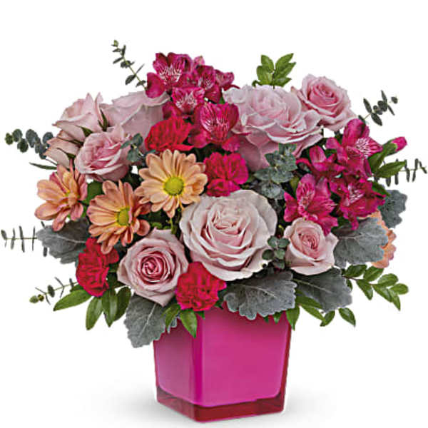 Pink and peach flower arrangement in a bright pink vase
