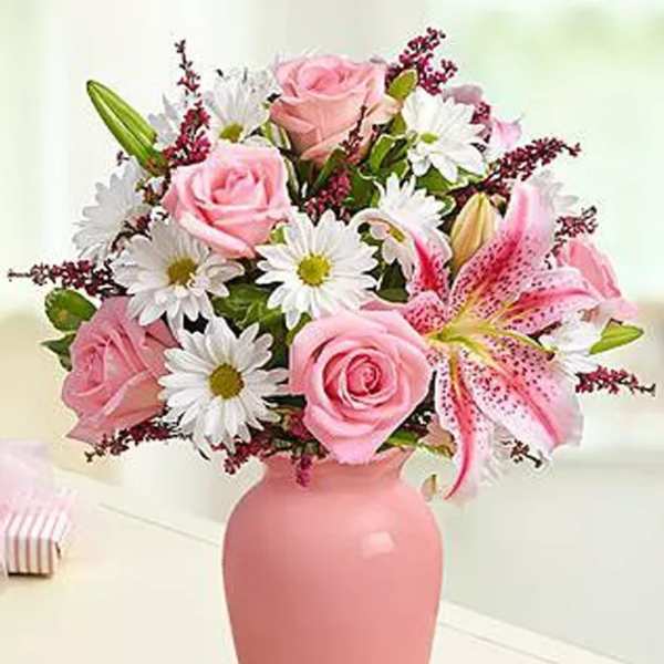 Pink roses and lilies in a pink vase with white daisies