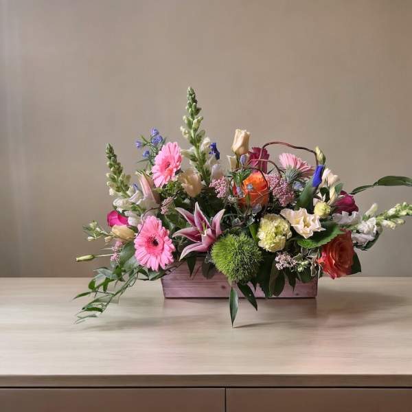 Mixed bouquet in a rectangular wooden box with pink and orange blooms