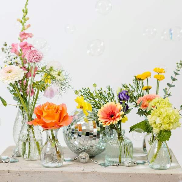 Colorful mixed flowers in small glass vases with a disco ball centerpiece