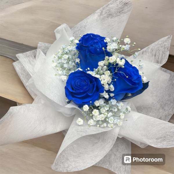 Bouquet of blue roses with white baby's breath in white wrap