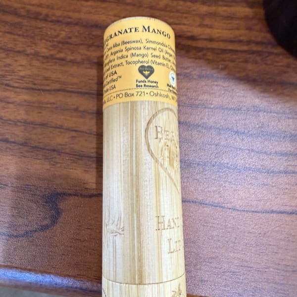 Yellow lip balm tube on a wooden surface