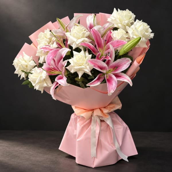 Pink and white bouquet of lilies and roses wrapped in pink paper