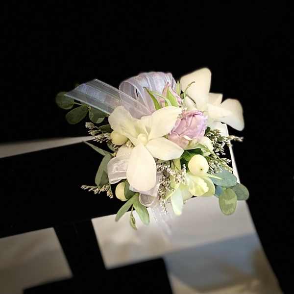Small wrist corsage with white and pale pink flowers on a ribbon band