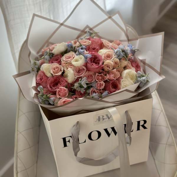 Bouquet of pink and cream roses in a gift bag