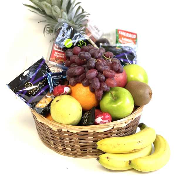 Fruit basket with grapes, apples, oranges, bananas, kiwi, and candy
