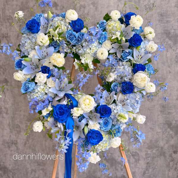 Blue and white floral wreath on a wooden stand