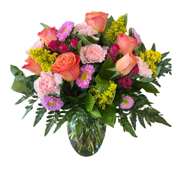 Mixed bouquet of roses, carnations, and daisies in a glass vase
