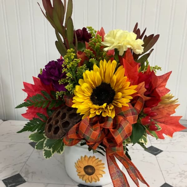 Fall floral arrangement with a sunflower in a white vase and plaid ribbon