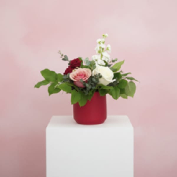 Bouquet of pink, white, and red flowers in a red vase