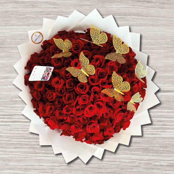 Heart-shaped bouquet of red roses with gold butterfly picks